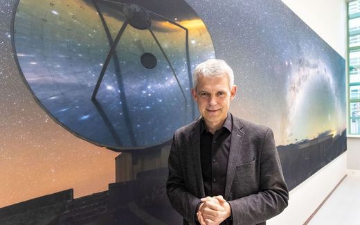 Astronomer Heino Falcke poses in front of a poster showing a space telescope at Radboud University's Faculty of Astronomy in Nijmegen. Photo RD, Anton Dommerholt