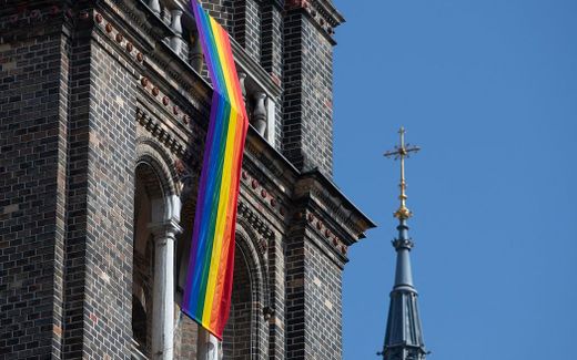 A LGBT rainbow flag hangs from on the steeple of a parish church. Photo AFP, Alex Halada