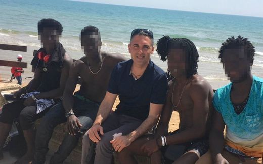 Francesco with some migrants around him. Photo Cédric Placentino