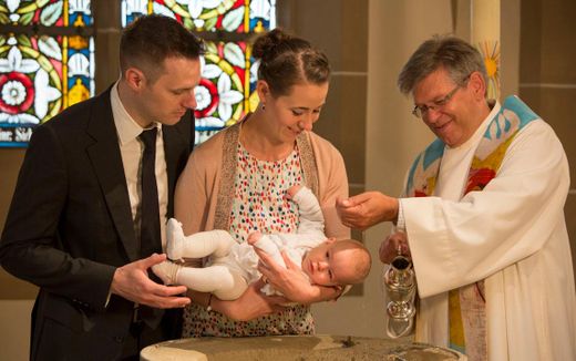 A Roman Catholic clergyman baptising a baby. Photo Bistum Mainz