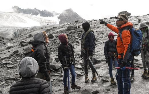 A teacher has something of a guide on the mountain. He points in the right direction. Photo AFP, Philippe Desmazes