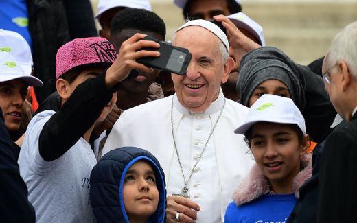 Pope Francis smiles for a selfie with refugees. Photo AFP, Vincenzo Pinto