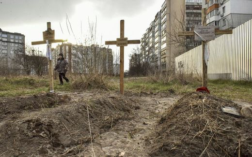 Graves are seen in front of a residential building in Bucha city. Photo EPA, Oleg Petrasyuk 