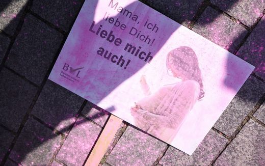 A placard reading 'Mama I love you! Love me too!' lies on the ground after counter protesters spread pink powder to disturb a 'March for Life' rally in September. Photo EPA, Clemens Bilan