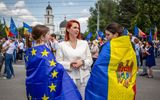 Moldova's Interior Minister Ana Revenco (C) speaks with participants wearing the Moldovan flag and the EU flag across their shoulders, during a pro-EU rally in Chisinau. Photo AFP, Elena Covalenco