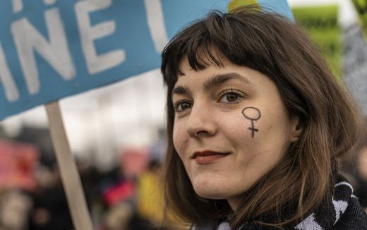 A protester has the symbol of the female sex painted on her face during a march of supporters and feminists for women's rights in Warsaw, Poland. Photo AFP, Wojtek Radwanski