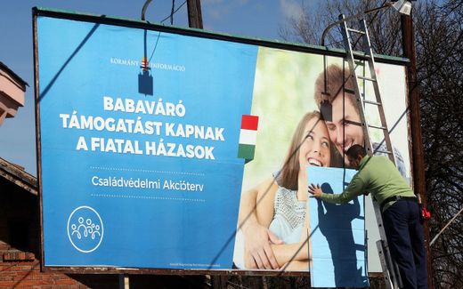 The billboard says: "Newlyweds receive baby-expecting support". Photo EPA, Janos Vajda
