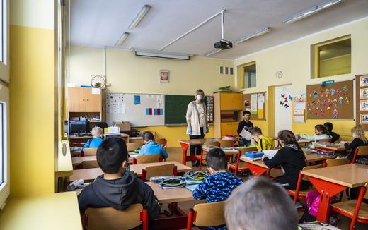 A teacher and first grade children in a classroom in the primary school number 25 in Warsaw. Photo AFP, Wojtek Radwanski