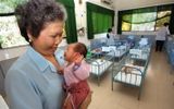 A nurse working in the Center of Deprived Children Tam Binh in Ho Chi Minh City (ex-Saigon) holds an abandoned child. Some of the orphans left in this center have been adopted by Europeans. Photo AFP, Hoang Dinh Ham
