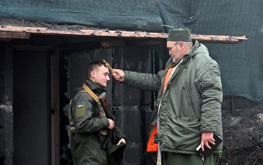 Military chaplain Father Oleksandr blesses a serviceman of the National Guard of Ukraine on their position in the north of Kharkiv region. Photo AFP, Sergey Bobok
