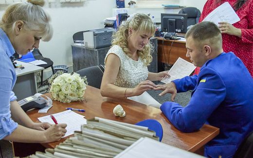 Ukrainian couple gets married in war time. Politician  Giorgiy Mazurashu pleads for more state measures against breaking the marriage vow. Photo EPA, Sergey Kozlov
