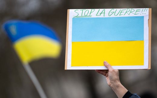 A placard showing the Ukrainian flag and a message that reads, 'stop the war'. Photo AFP, Loic Venance