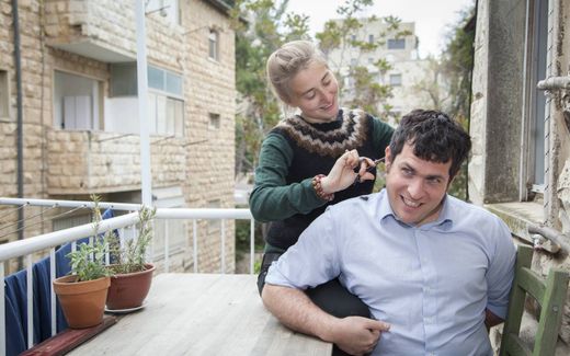 A young Germany lady is cutting the hair of her Israeli partner. Photo Katja Harbi
