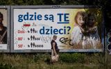 A woman walks past a billboard with the lettering 'Where are these children?' in Warsaw, on August 5, 2022. The billboards, put up in recent weeks by a Catholic foundation, are hard to miss: large and plastered all over Poland, they show two little blonde girls in immaculate white posing in a wheat field -- along with the alarmist caption, "Where are these children?" Falling birth rate statistics displayed alongside in the form of a pictogram claim that the average Polish family had five children in the 1950s, down to three in the 80s and 1.5 today. Photo AFP, Wojtek Radwanski