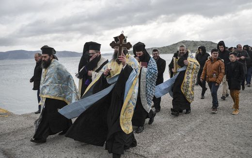 A group of Greek Orthodox priests walking along the shore. Picture has no relation with the subject of the article. Photo AFP, Louisa Gouliamaki