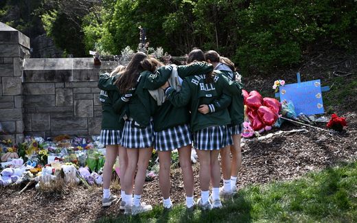 Girls embrace in front of a makeshift memorial for victims by the Covenant School building at the Covenant Presbyterian Church following a shooting, in Nashville, USA. Photo AFP, Brendan Smialowski
