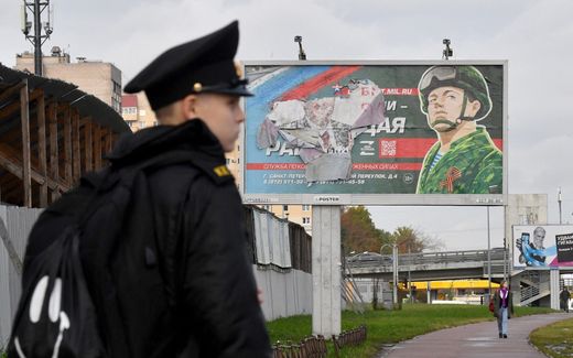 A military cadet stands in front of a billboard promoting contract army service in Saint Petersburg. Photo AFP, Olga Maltseva
