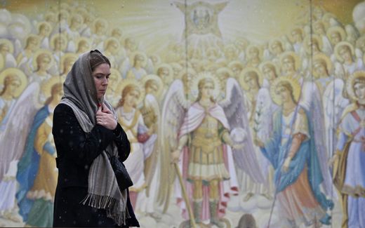 A Ukrainian woman during an Orthodox liturgy. The government tries to discourage the use of languages other than Ukrainian in worship. Photo AFP, Genya Savilov