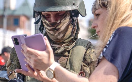 A lady shows a Wagner soldier how the photo she made looks like. Troops of Wagner leader Yevgeny Prigozhin rebelled against President Putin last Saturday. Photo AFP, Roman Romokhov
