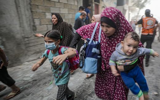 A Palestinian mother fleeing violence with her children. Photo EPA, Mohammed Saber