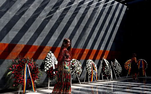 Roma woman who wears a traditional outfit pays respect for the victims inside the memorial room during a ceremony marking the Roma Holocaust Memorial Day, held at the Holocaust Memorial in Bucharest, Romania. Photo EPA, Robert Ghement