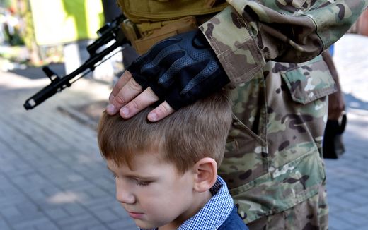 A Ukrainian battalion member touches his child. Photo AFP, Sergei Supinsky