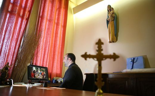 Priest behind his laptop. Image not related to article. Photo AFP, Pascal Pochard-Casabianca 