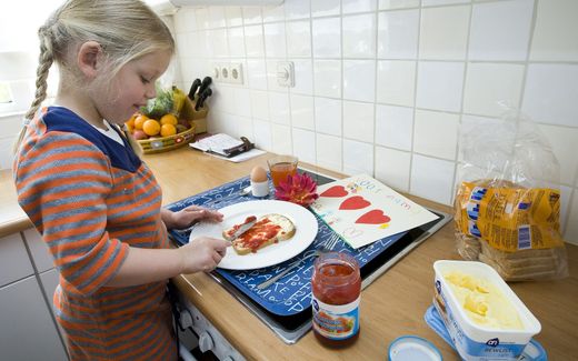 A girl makes breakfast for her mother as a gift for Mother's Day. Photo ANP, Lex van Lieshout 