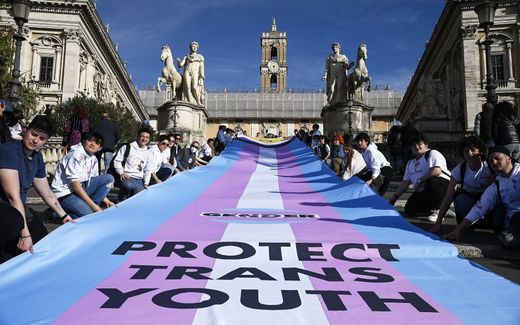 Demonstrators unroll a banner reading 'Protect Trans Youth' on the steps of the Campidoglio during a rally. Photo EPA, Riccardo Antimiani