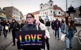 A demonstrator holds up a placard reading 'Love - is a terrible thing to hate' as people march during a protest in downtown Bratislava, two days after a 'radicalised teenager' shot dead two men at the Teplaren bar, a gay bar. Photo AFP, Vladimir Simicek
