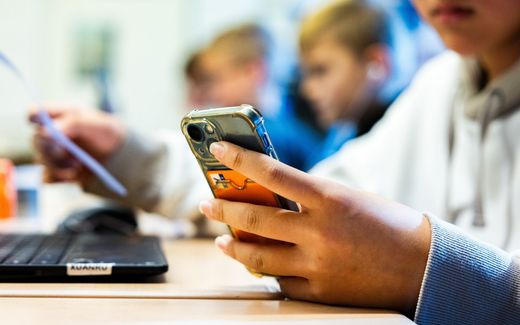 Primary school students with their smartphone in the classroom. This will no longer be allowed at Dutch primary schools and schools for pupils with special needs. Photo ANP, Jeffrey Groeneweg
