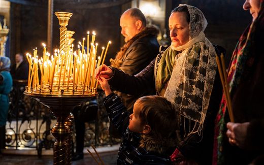 Worshippers light candles during an Orthodox Christmas service in Kyiv. Photo AFP, Sameer Al-Doumy
