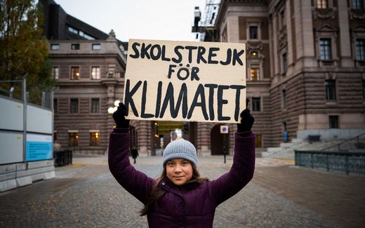 Swedish climate activist Greta Thunberg poses for a picture holding a sign reading "School strike for Climate" as she protests in front of the Swedish Parliament (Riksdagen) in Stockholm. Photo AFP, Jonathan Nackstrand
