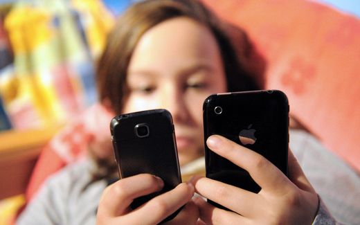 Child looking at her phone. According to the French authorities, minors can access pornographic websites too easily. Photo AFP, Denis Charlet