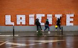 Three feminist activists placard posters of a drawing by French cartoonist Charb to read " Laicite " in Montreuil, on October 20, 2020. Photo AFP
