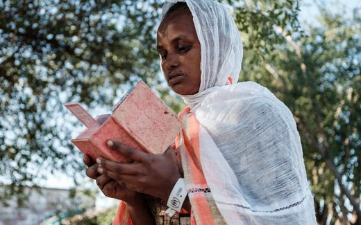 Christian refugee from Ethiopia reading her Bible. Photo AFP, Yasuyoshi Chiba