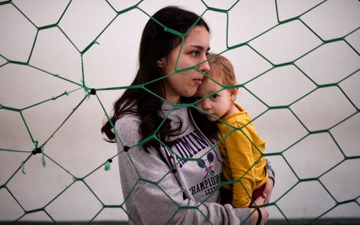Ukrainian refugee Rahela Captari holds a child at a sports arena converted into a temporary shelter for Ukrainian refugees. Image not related to article. Photo AFP, Armend Mimani
