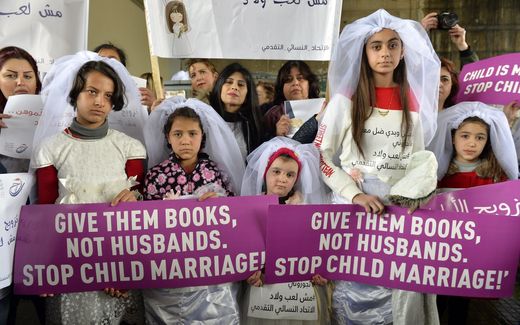  Young Lebanese girls carry placards as they participate in a march against child marriage. Photo EPA, Wael Hamzeh