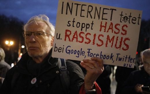 A Germanman holds a poster reading "Internet kills - stop hate and racism at Google, Facebook, Twitter etc". Photo AFP, David Gannon
