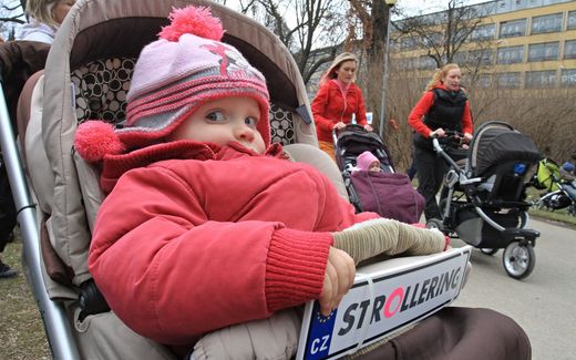 A baby girl looks on while two young women push their children in a stroller during the race walking competition in Brno, Czech Republic. Photo AFP, Radek Mica