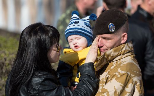 A Ukrainian marine shares a tender moment with his family. Photo AFP, Dmitry Serebryakov