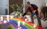 An LGBT activist places a candle in a church. Photo EPA, Ennio Leanza
