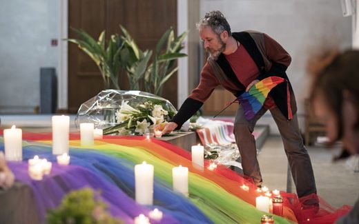 An LGBT activist places a candle in a church. Photo EPA, Ennio Leanza