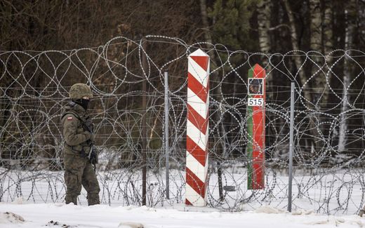 A Polish soldier patrols at the barbed wire fence along the Polish-Belarusian border. Photo AFP, Wojtek Radwanski
