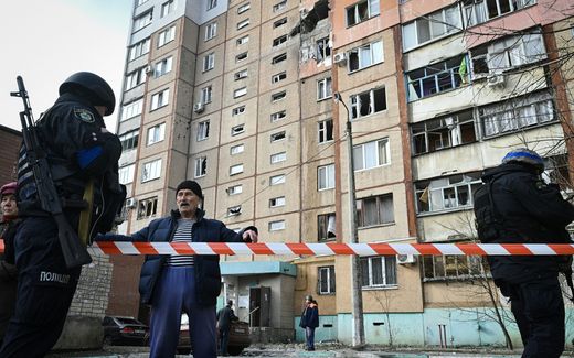 A local resident speaks to a police officer in front of residential multi-story building damaged following Russian strike, in Kherson. Photo AFP, Genya Savilov