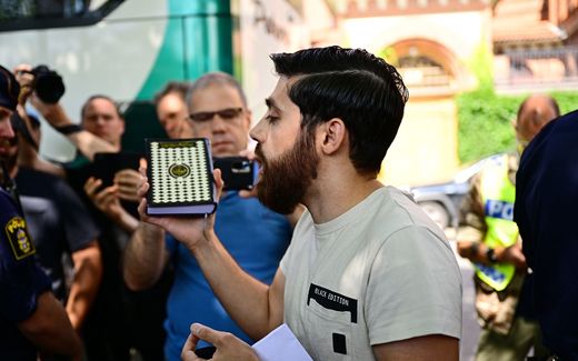Ahmad A., who has been given permission by the police for a public gathering to burn a Torah and a Bible outside the Isaeli embassy, speaks to members of the media. The man chose not to burn the books but to hold a manifestation holding a Koran book in his hand. Photo EPA, Magnus Lejhall