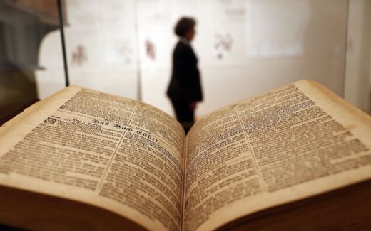 A woman walks past the Sauer Bible that is part of the exhibition 'The Luther Effect - 500 Years Protestantism in the World' at the Martin Gropius Bau, Berlin, Germany. Photo EPA, Felipe Trueba