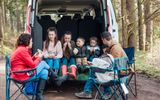 A family with four children eating lunch in the back of their van. Photo iStock