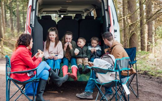 A family with four children eating lunch in the back of their van. Photo iStock