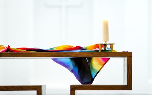 Rainbow flag lies in on a table in a church. Photo ANP, Remko de Waal
